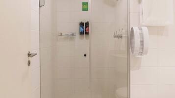Un box de ducha con paredes de cristal, un inodoro y un perchero en un baño.
