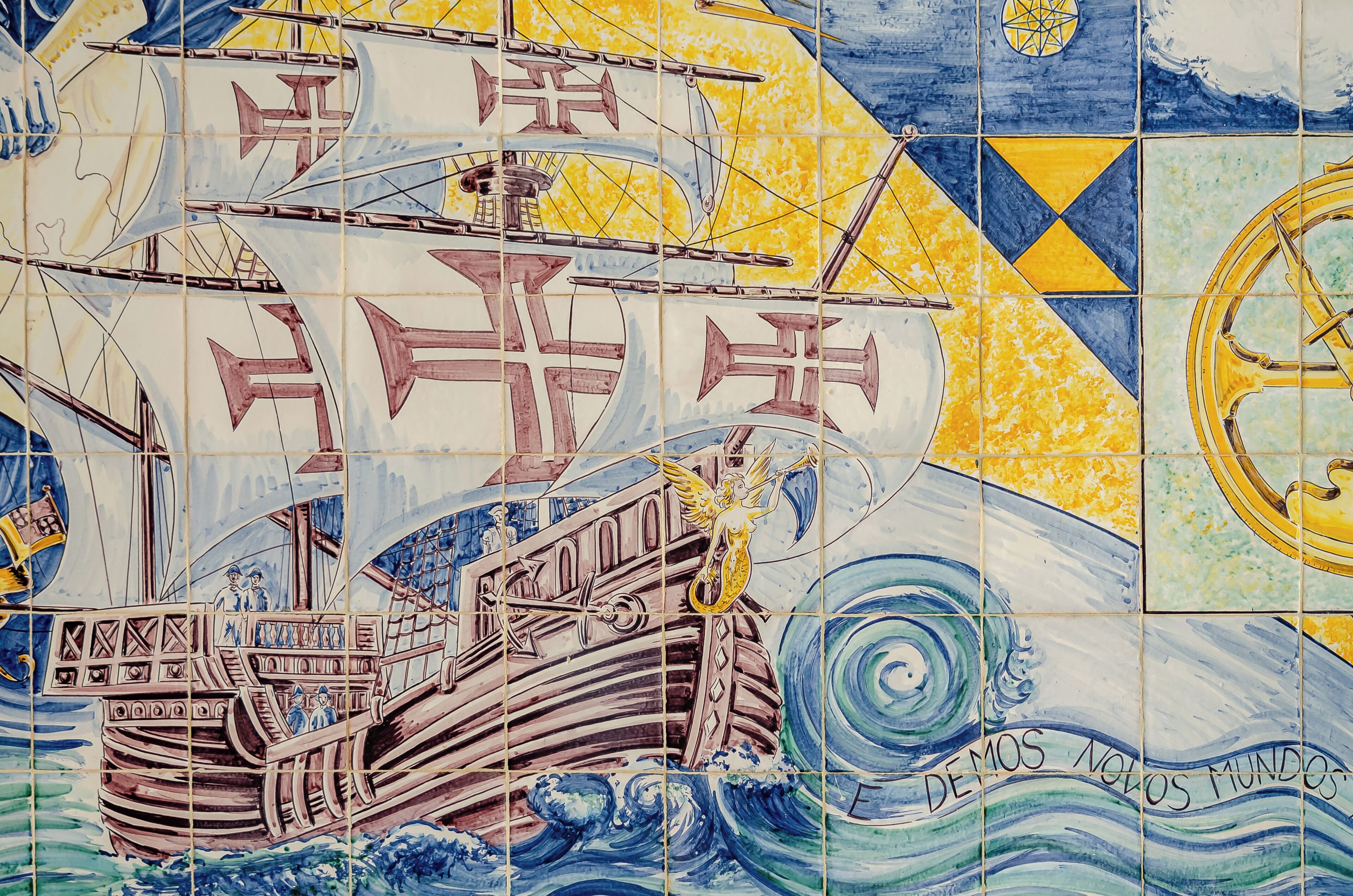 Pared de azulejos con escena marina, que incluye un barco y olas.