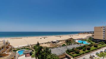 A resort with multiple swimming pools, a beach, and a view of the sea.