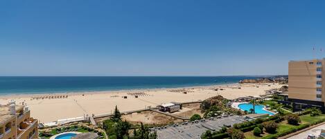 Un resort con varias piscinas, una playa y vista al mar.