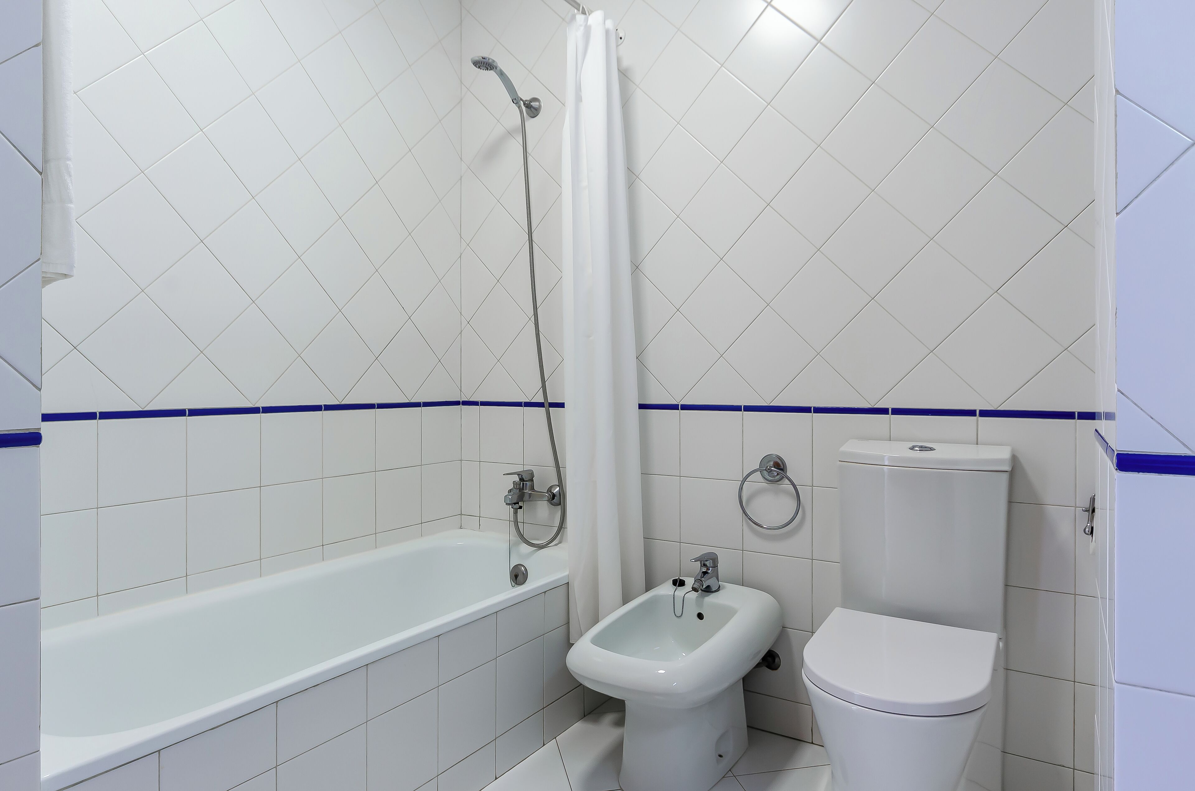 A bathroom with a bathtub, bidet, and toilet.