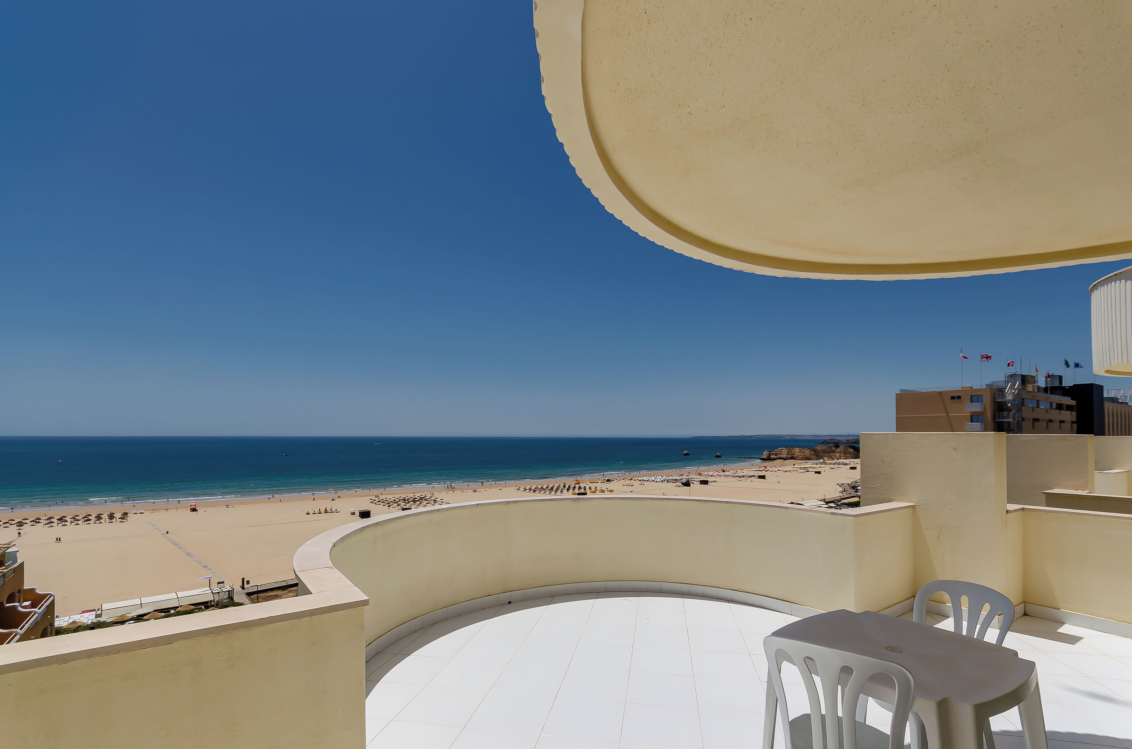 Een balkon met uitzicht op een strand en de zee.