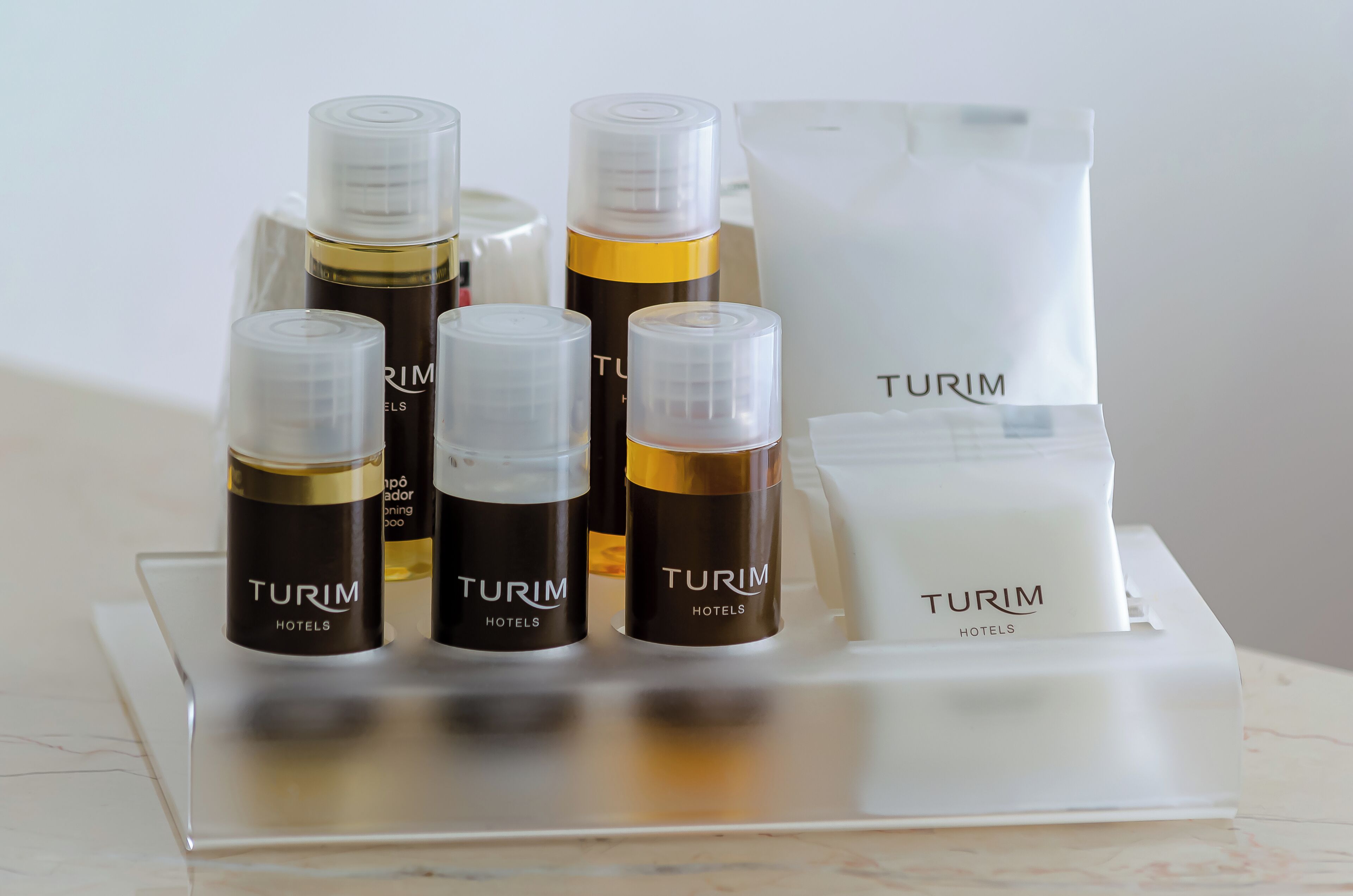 A set of toiletries including bottles and a bag, all branded with 'Turim Hotels'.