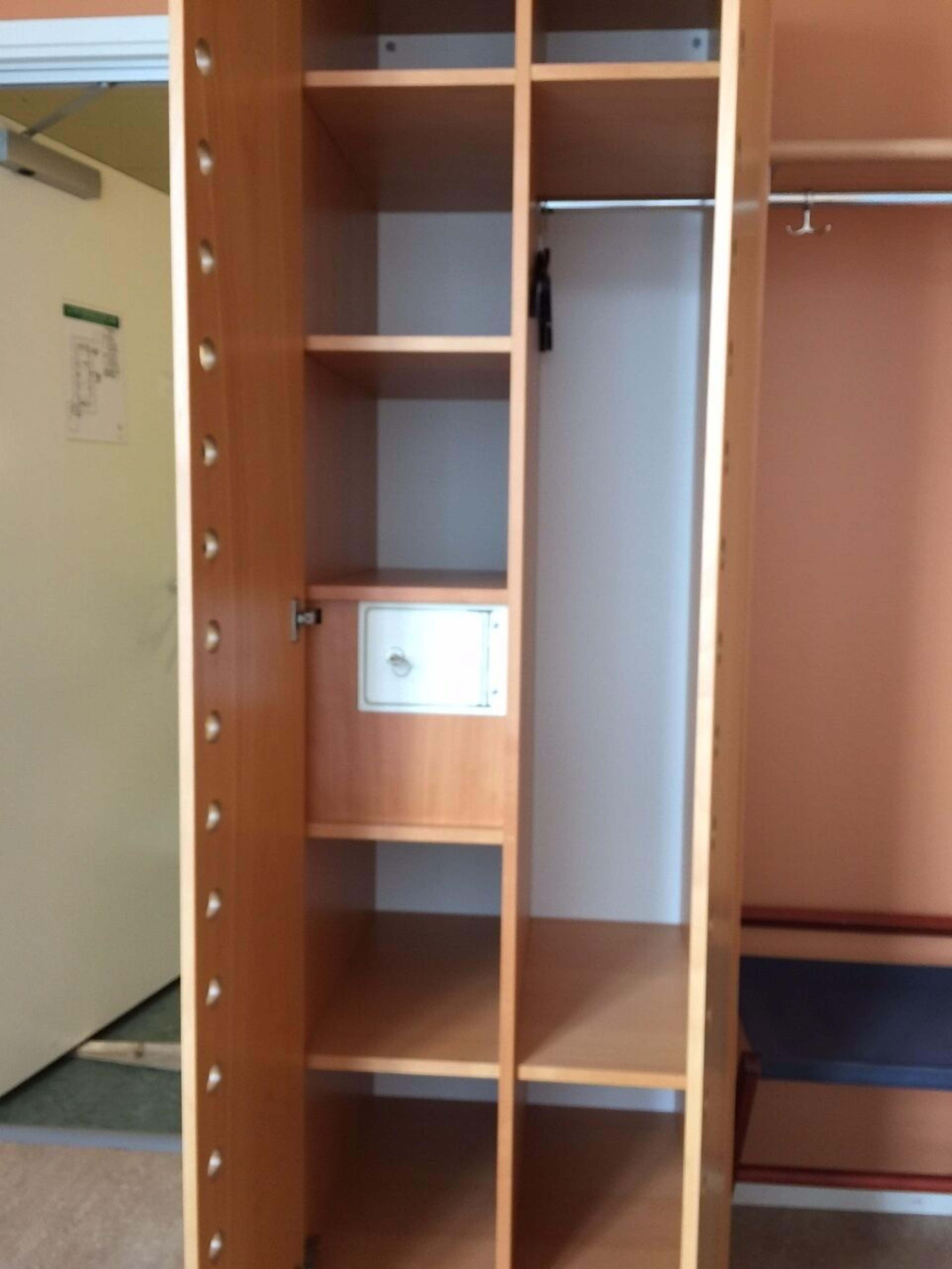 Ein Holzschrank mit mehreren Einlegeböden und einem abschließbaren Fach.