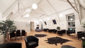 Un loft espacioso con techos altos, comedor, zonas de estar y un amplio ventanal.