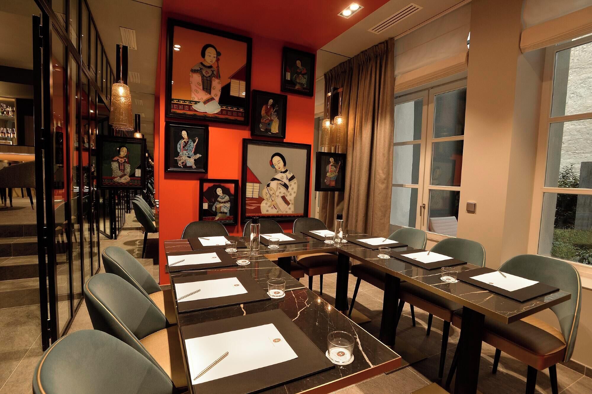 Une salle de conférence avec une longue table, des chaises et des œuvres d’art encadrées accrochées aux murs.