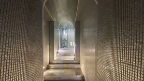 A corridor with a tiled floor and walls, leading to a staircase. - Hôtel La Lanterne & Spa By Timhotel (Paris)