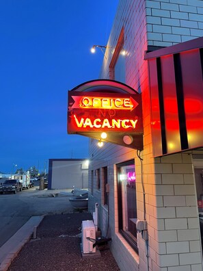 A building with a neon sign indicating an office vacancy. - Rainbow Motel (Greeley)