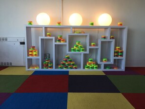 A white shelving unit with multiple compartments, each containing colorful cylindrical objects labeled 'Motel'. - Rainbow Motel (Greeley)