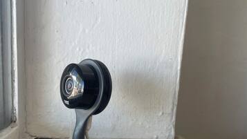 A security camera mounted on a wall corner.