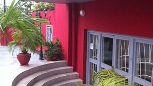 Un edificio rojo con una escalera curva que conduce a una puerta con un ventanal.