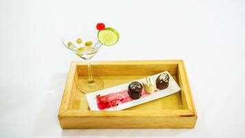 Un plateau en bois avec un verre à martini et une assiette de desserts.
