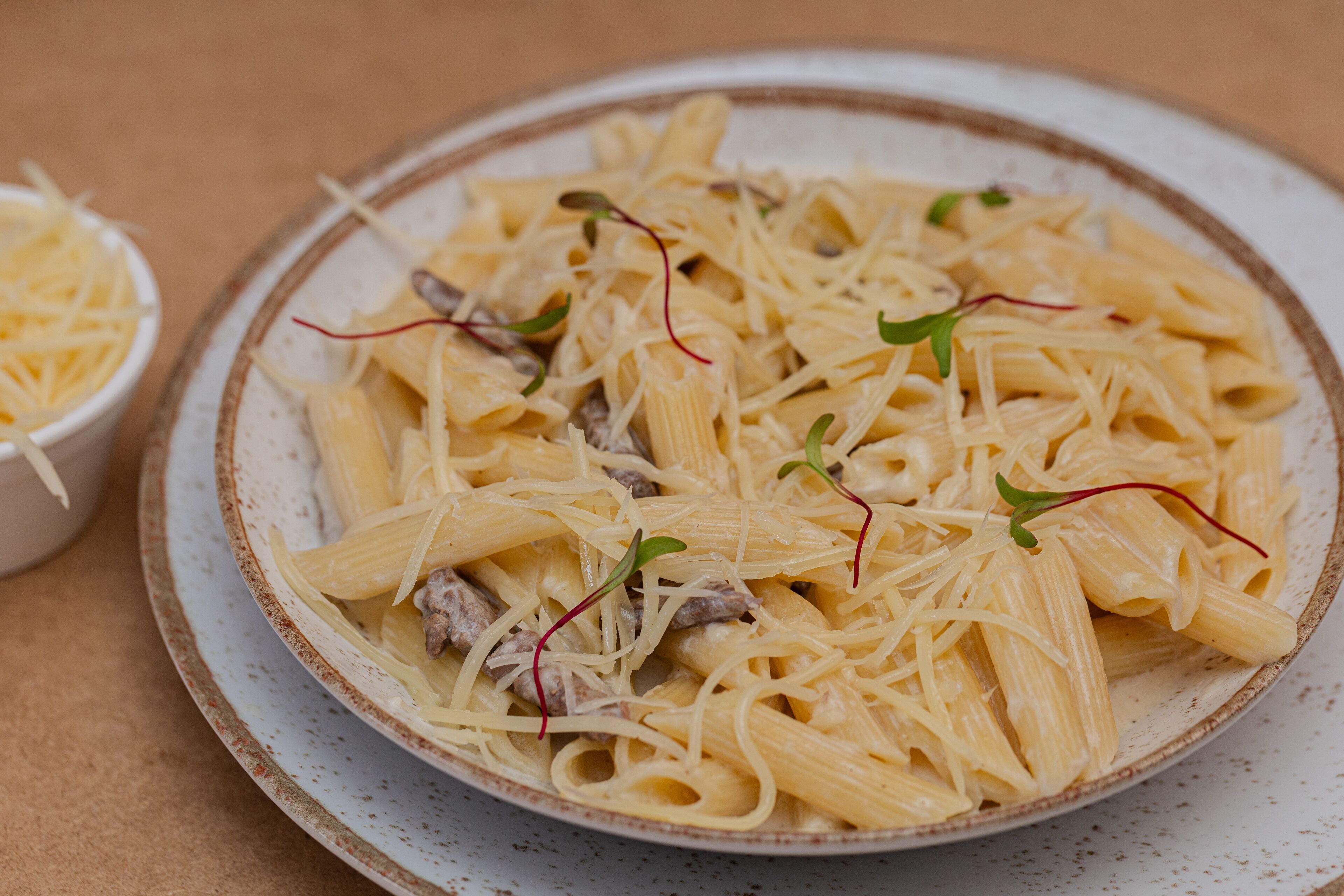 Eine Portion Pasta mit Fleisch und Beilagen.