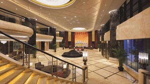 A spacious lobby with a grand staircase, marble flooring, and a large chandelier. - Wyndham Urumqi North (Miquan)