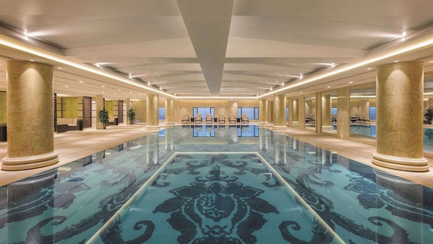 A spacious lobby with a reflective floor, large columns, and seating areas. - Wyndham Urumqi North (Miquan)