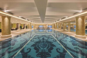 A spacious lobby with a reflective floor, large columns, and seating areas.