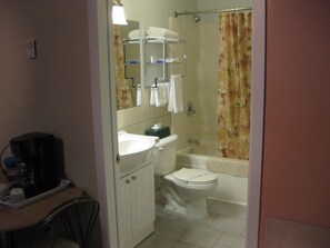 Bathroom features a white toilet, sink, shower, and bathtub.