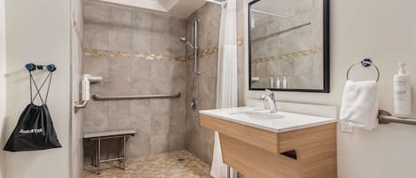 A modern bathroom with a shower, vanity, and a large mirror.