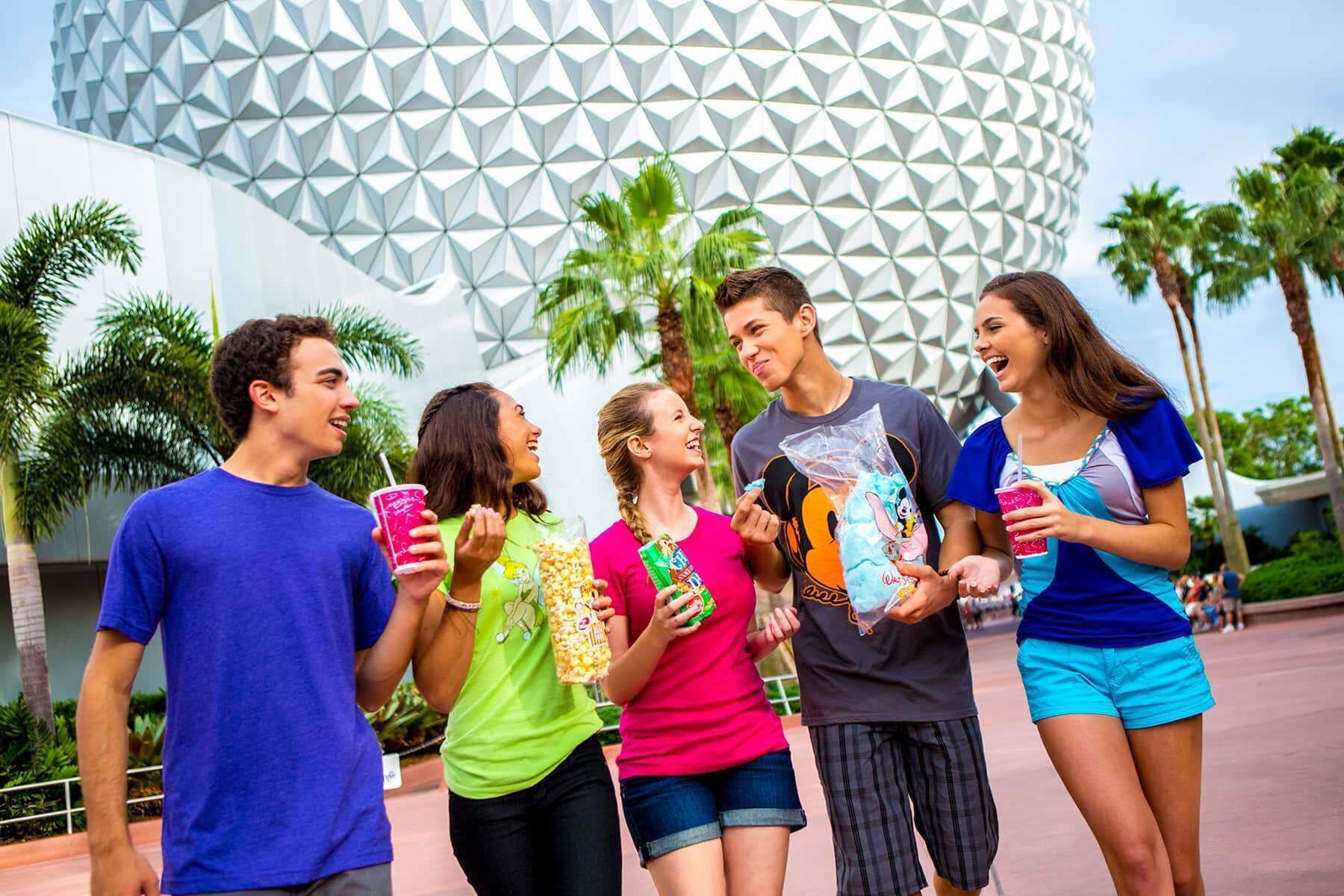 A group of people standing in front of a building with a distinctive geometric pattern.