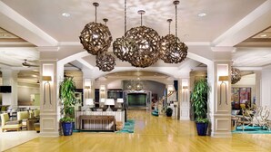 A spacious lobby with a high ceiling, large chandeliers, and a central seating area. - Wyndham Garden Lake Buena Vista – Disney Springs® Area (Lake Buena Vista)