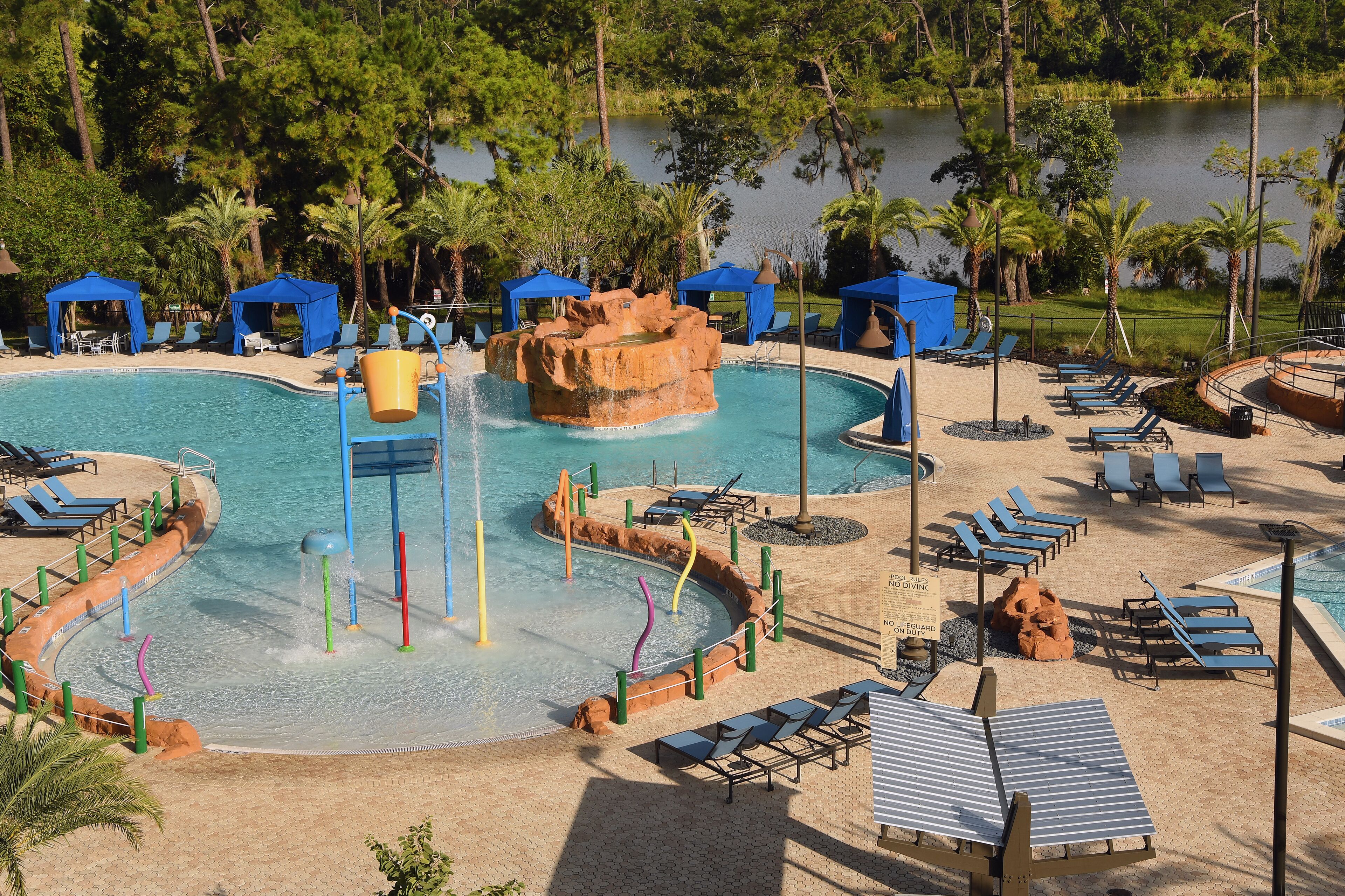 A pool area with water slides, lounge chairs, and umbrellas.