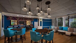A modern bar area with a bar counter, seating, and hanging light fixtures. - Wyndham Garden Lake Buena Vista – Disney Springs® Area (Lake Buena Vista)