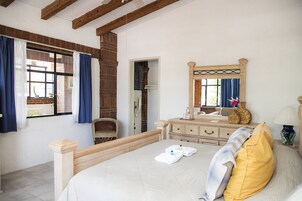 Un dormitorio con cama, cómoda, espejo y ventana con cortinas.