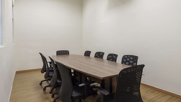 A conference room with a wooden table and black chairs. - Tulip Inn Sete Lagoas (Sete Lagoas)