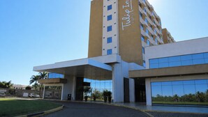 Un hotel moderno con una entrada destacada, ventanas amplias y un cielo despejado.