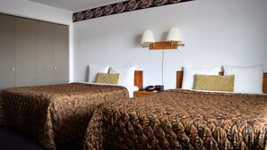 A hotel room with two beds, a wardrobe, a bedside table with a lamp, and a telephone. - Littletree Inn (Granby)