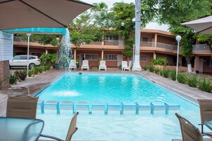 Una piscina al aire libre, camas de piscina gratis, sombrillas
