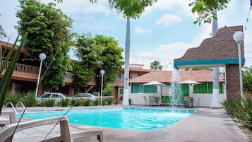Una piscina al aire libre, camas de piscina gratis, sombrillas