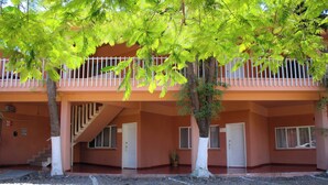 Un edificio de dos pisos con un balcón, una escalera y una puerta.