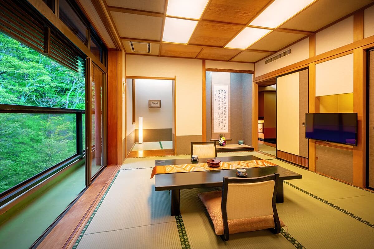 Une pièce de style japonais traditionnel, avec un sol recouvert de tatamis, une table basse et des portes coulissantes.