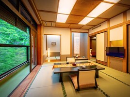 Una habitación japonesa tradicional con suelo de tatami, una mesa baja y puertas correderas.