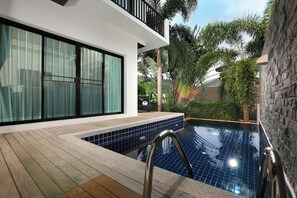 A modern outdoor swimming pool with a wooden deck and a glass balustrade. - Thaimond Residence by TropicLook (Rawai)