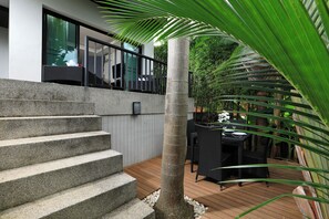 A modern outdoor staircase leading to a balcony with a view of a lush garden. - Thaimond Residence by TropicLook (Rawai)