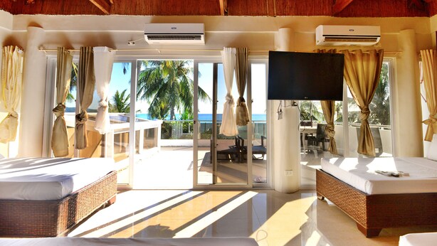 A room with a large bed, a TV, and a view of the ocean. - Kaiyana Boracay Beach Resort (Boracay Island)