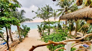 A beach view with palm trees and a thatched-roof structure. - Kaiyana Boracay Beach Resort (Boracay Island)