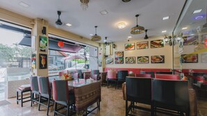 A restaurant interior with booths, tables, and chairs. - Royal Beach Residence (Patong)