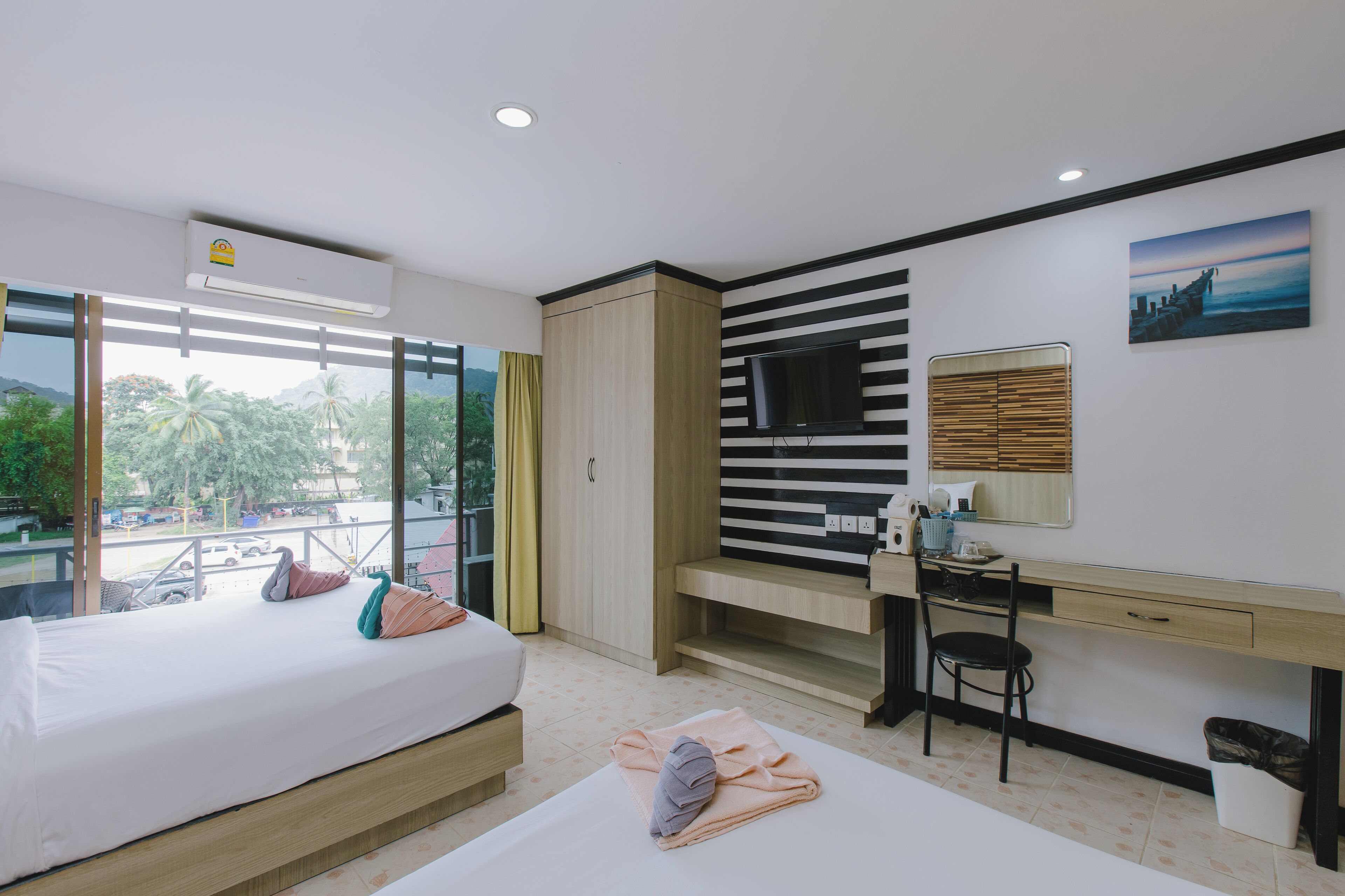 Una habitación de hotel moderna con cama, escritorio y ventanas amplias con vistas panorámicas.