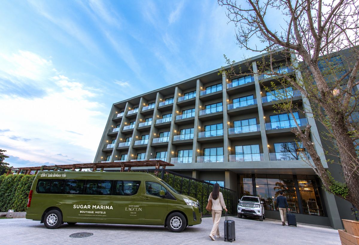 A modern hotel building with a green van labeled 'Sugar Marina Boutique Hotels' parked in front.