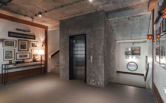 A lobby with a staircase, a reception desk, and a wall with framed pictures.