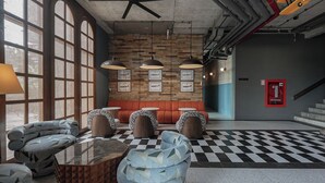 A modern lounge area with a checkered floor, seating with patterned cushions, and pendant lighting. - Sugar Marina Hotel - AVIATOR - Phuket Airport (Sa Khu)