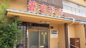 A traditional Japanese building with a tiled roof and a signboard with Japanese characters. - Yourou Onsen Honkan (Onomichi)