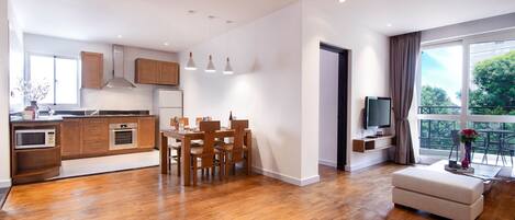 A modern apartment with a kitchen, dining area, and living room.