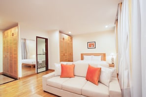 Una habitación de hotel con cama, sofá, baño y armario.