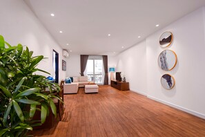 En moderne stue med sofa, fjernsyn og spiseplads med stole.