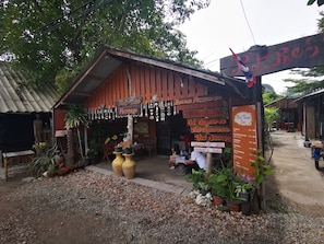 A Red Tuna Spa with a wooden exterior, signage for various massage services, and potted plants around the entrance. - PP Red Tuna Hut (Ko Phi Phi)