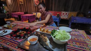 A dining table with a fish, salad, and condiments. - PP Red Tuna Hut (Ko Phi Phi)